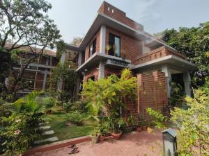 uma casa de tijolos com plantas em frente em Elim-A Sedate Nest em Santiniketan