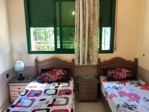 1 Schlafzimmer mit 2 Betten und 2 Fenstern in der Unterkunft Typique Appartement-Villa in Al Hoceïma