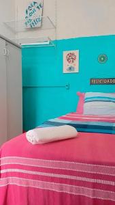 a bedroom with a bed with a pink and blue wall at Hostel Recife Bar quartos climatizados das 22h às 6h in Recife