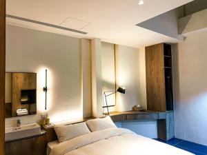 um quarto com uma cama, um espelho e um lavatório em UNS B&B em Kaohsiung