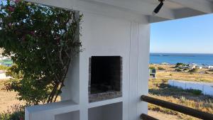 a screened in porch with a fireplace with a view of the ocean at View on the Bay 7 Pinta Crescent in St Helena Bay