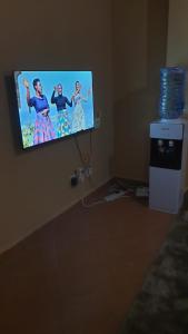 TV de pantalla plana colgada en la pared en LAURAPA home's, en Kisumu