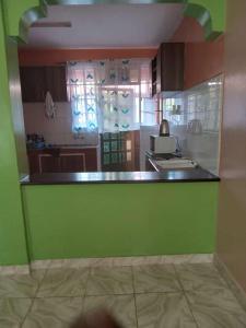 cocina con encimera verde en una habitación en LAURAPA home's, en Kisumu