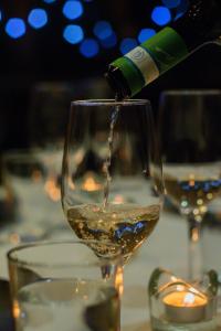 une bouteille de vin servie dans un verre de vin dans l'établissement Hotel du Lac, à Villars-sur-Ollon