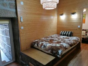 ein Schlafzimmer mit einem Bett in einer Holzwand in der Unterkunft Era Uma Vez Apartment in Vila Real