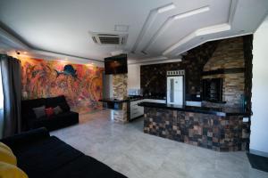 a living room with a couch and a kitchen at Pousada Mirante do César in Bombinhas