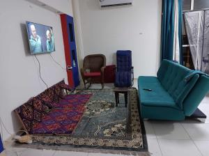 a living room with a couch and a chair at nice room inside an apartment in Abu Dhabi