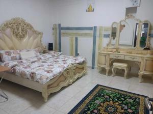a bedroom with a bed and a vanity with a mirror at nice room inside an apartment in Abu Dhabi