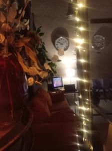 a living room with a couch and a clock and lights at Albergue & Cafetería Vía de la Plata Hervás in Hervás