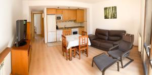 a kitchen and a living room with a table and a couch at Casa Chuanina in Benasque