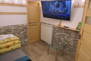 um quarto com uma televisão na parede e uma cama em Kamping u Łukasza em Zakopane