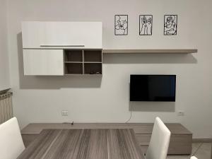 cocina con armarios blancos y TV de pantalla plana en Sottomarina Beach apartment, en Chioggia