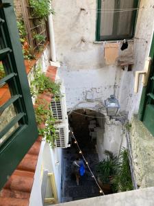 vista in alto su un vicolo con una persona seduta in un edificio di CASA ICARO ad Amalfi