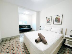 a bedroom with a large white bed with a towel on it at Picaflor 7 Amazing Cozy Apt @ Miramar in San Juan