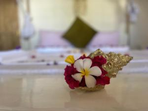 Villa Upendo Paje في باجي: مزهرية من الزهور تقف على طاولة