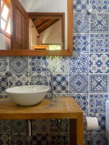 ein Bad mit einem Waschbecken und blauen und weißen Fliesen in der Unterkunft Pousada Albatroz in Abraão
