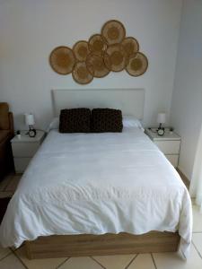 a bedroom with a large white bed with two night stands at Paraje El Pozo in Málaga