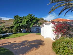 a house with a white gate and a driveway at Paraje El Pozo in Málaga