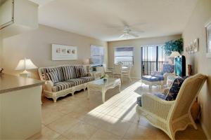 uma sala de estar com um sofá, cadeiras e uma mesa em Emerald Isle 601 em St. Pete Beach