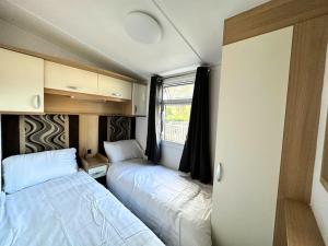 um pequeno quarto com duas camas numa caravana em Beautiful newly decorated cabin em Great Billing