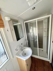 y baño blanco con lavabo y ducha. en Beautiful newly decorated cabin en Great Billing