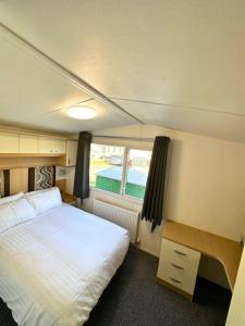 um pequeno quarto com uma cama e uma janela em Beautiful newly decorated cabin em Great Billing