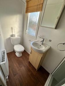 a white bathroom with a toilet and a sink at Beautiful newly decorated cabin in Great Billing