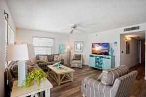 a living room with two couches and a tv at Emerald Isle 603 in St Pete Beach