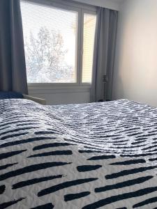 een slaapkamer met een groot bed en een raam bij Huttunen - Ihqu kolmio loistavalla sijainnilla in Iisalmi