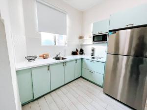 a kitchen with blue cabinets and a stainless steel refrigerator at Picaflor 1 Lovely Comfy Apt W/ King & Sofa Bed in San Juan