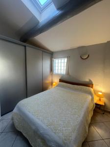 a bedroom with a bed and a window with two lamps at Le Zenith in L'Isle-sur-la-Sorgue