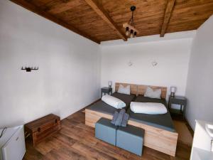 1 dormitorio con 1 cama grande y techo de madera en Levendulászat, en Simontornya
