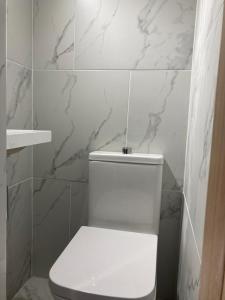 a white toilet in a bathroom with marble tiles at Twin home with free parkings, Surbiton, Kingston upon Thames, Surrey, Greater London, UK! in Surbiton