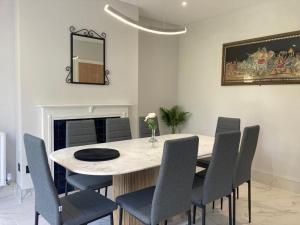 a dining room with a table and chairs and a mirror at Twin home with free parkings, Surbiton, Kingston upon Thames, Surrey, Greater London, UK! in Surbiton