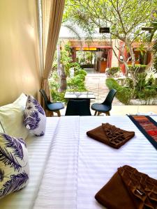 a white bed with towels and chairs in a room at Family House Resort, Haad Rin in Haad Rin