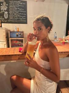 a woman in a white dress drinking a drink at Drifters Zanzibar in Paje +38 photos
