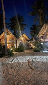 a group of houses on a beach at night at Drifters Zanzibar in Paje