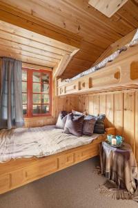a large bed in a log cabin with a window at Flott hytte i Vrådal rett ved alpinbakken in Vradal
