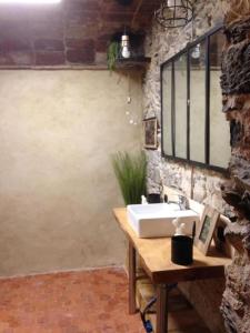 a bathroom with a sink and a stone wall at Jolie maison catalane chaleureuse et confortable in Colera +22 photos