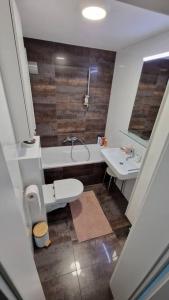 a bathroom with a tub and a toilet and a sink at Apartma VAL in Maribor