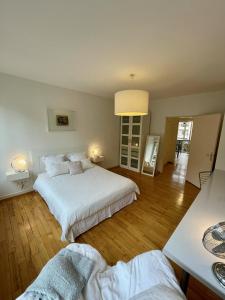 a white bedroom with two beds and a table at Appartement Hyper Centre Place Kléber in Strasbourg