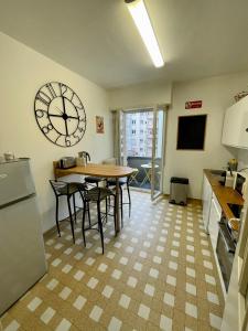 a kitchen with a table and a large clock on the wall at Appartement Hyper Centre Place Kléber in Strasbourg