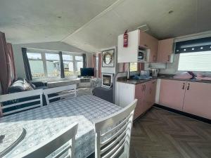 eine Wohnküche mit einem Tisch und einem Esszimmer in der Unterkunft Modern Caravan With Wifi At Martello Beach Holiday Park In Essex Ref 29010kv in Clacton-on-Sea