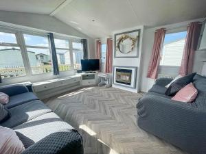 ein Wohnzimmer mit 2 Sofas und einem TV in der Unterkunft Modern Caravan With Wifi At Martello Beach Holiday Park In Essex Ref 29010kv in Clacton-on-Sea