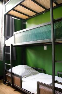 a bedroom with two bunk beds with a green wall at Amsterdam Hostel Orfeo in Amsterdam