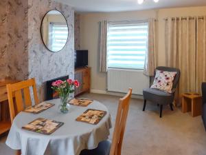 a dining room with a table and a mirror at End Cottage in Horncastle