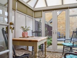 a screened in porch with a table and chairs at Jasmine Cottage in Chipping Campden