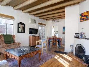 een woonkamer met een tafel en een open haard bij Casita Stieglitz in Santa Fe