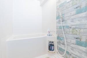 a bathroom with a white toilet with a hose at Apartment hotel Hana in Yokohama in Yokohama