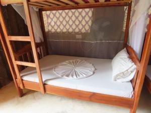 a bunk bed with a white pillow on it at Drifters Zanzibar in Paje